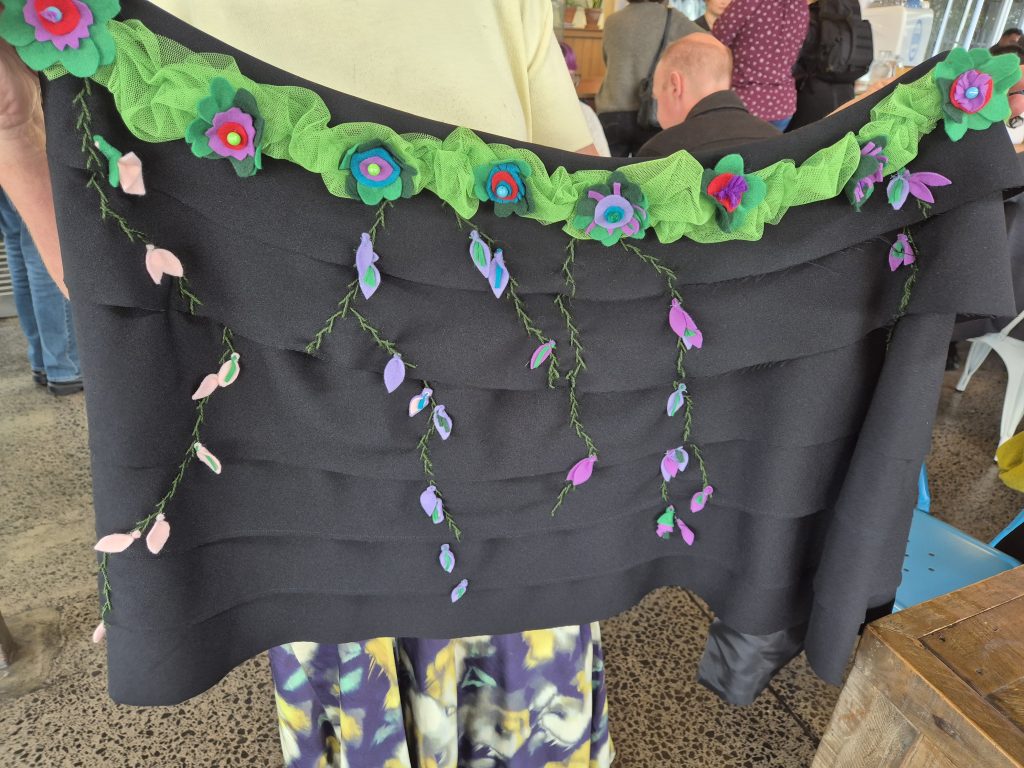 Woven cloak held up for display