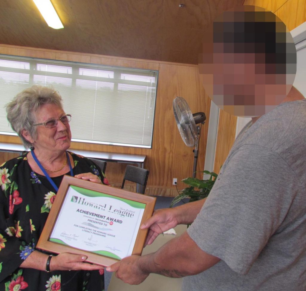 Older woman gives certificate to man