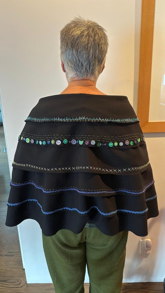 Back of woman wearing embroidered cloak