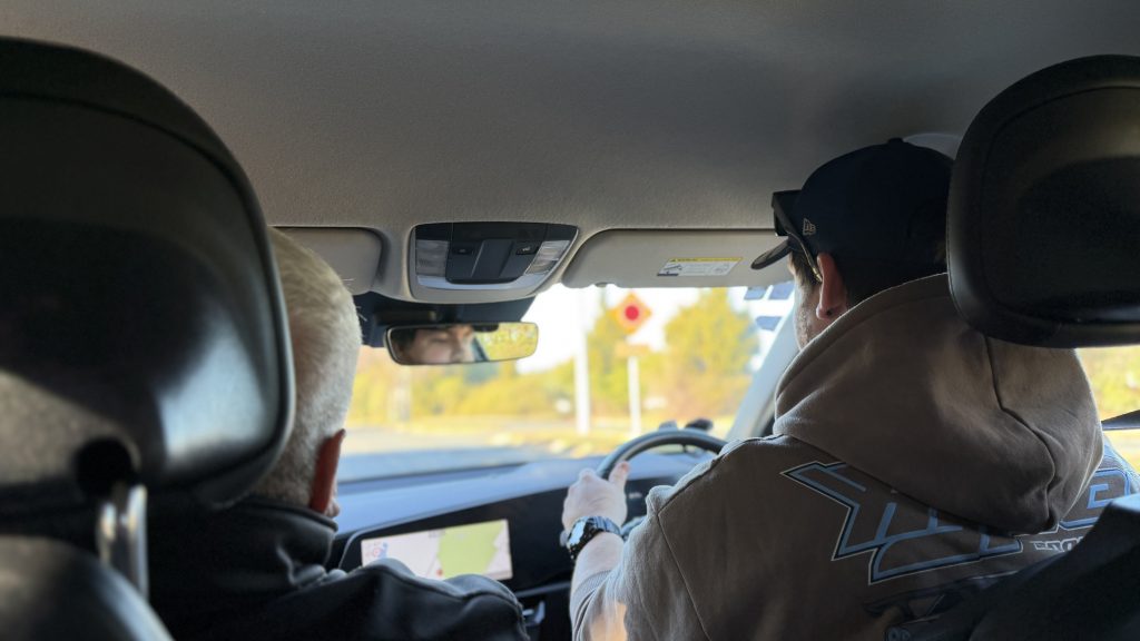 Two men in the front of a car.