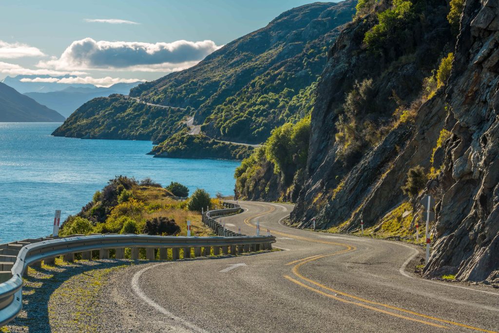 winding road with sea and mountains in the background.
